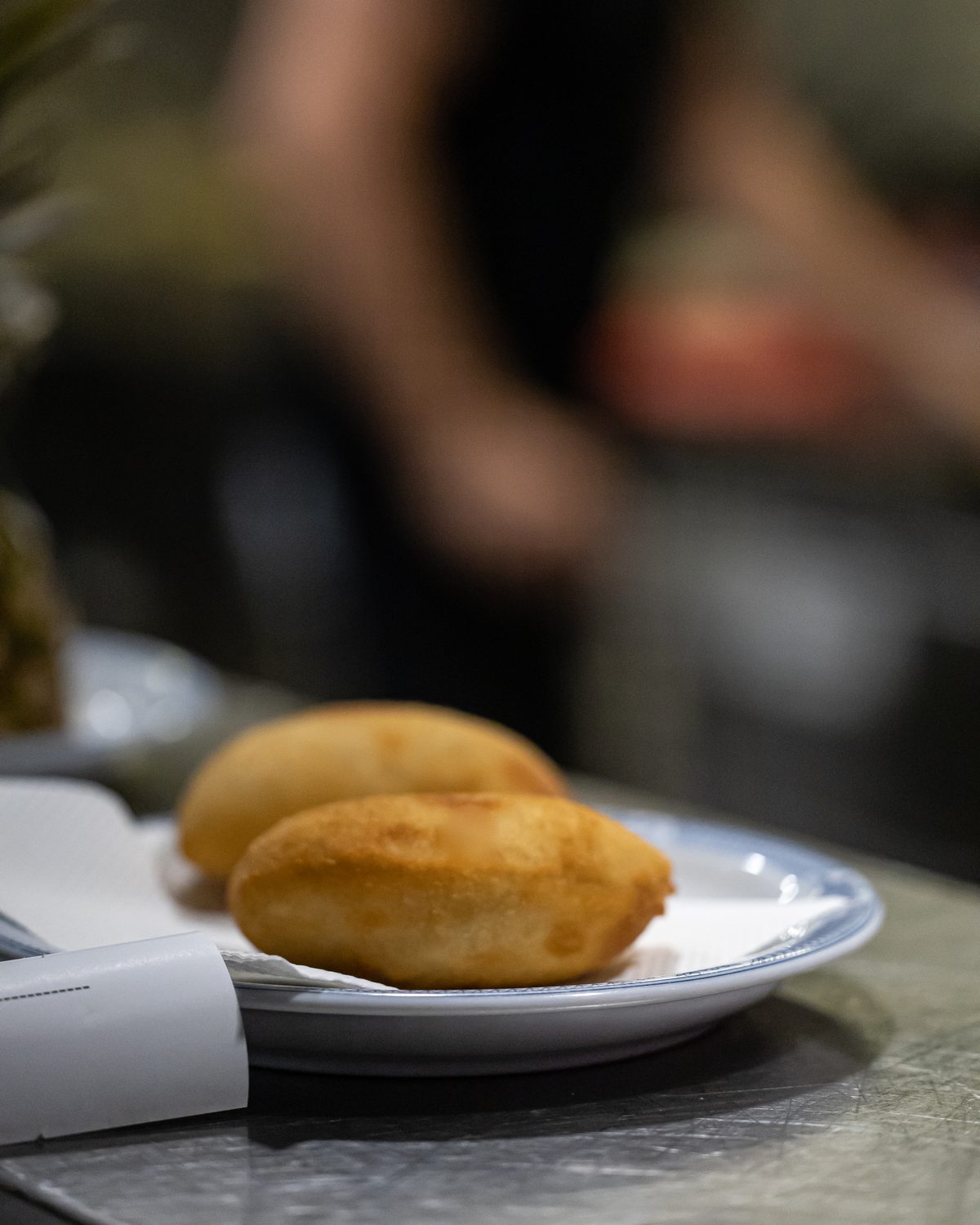 Two golden rissóis served on a plate at a Porto restaurant table
